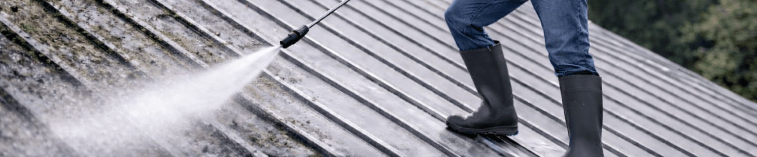 Man Power Washing a Metal Roof Wide Angle